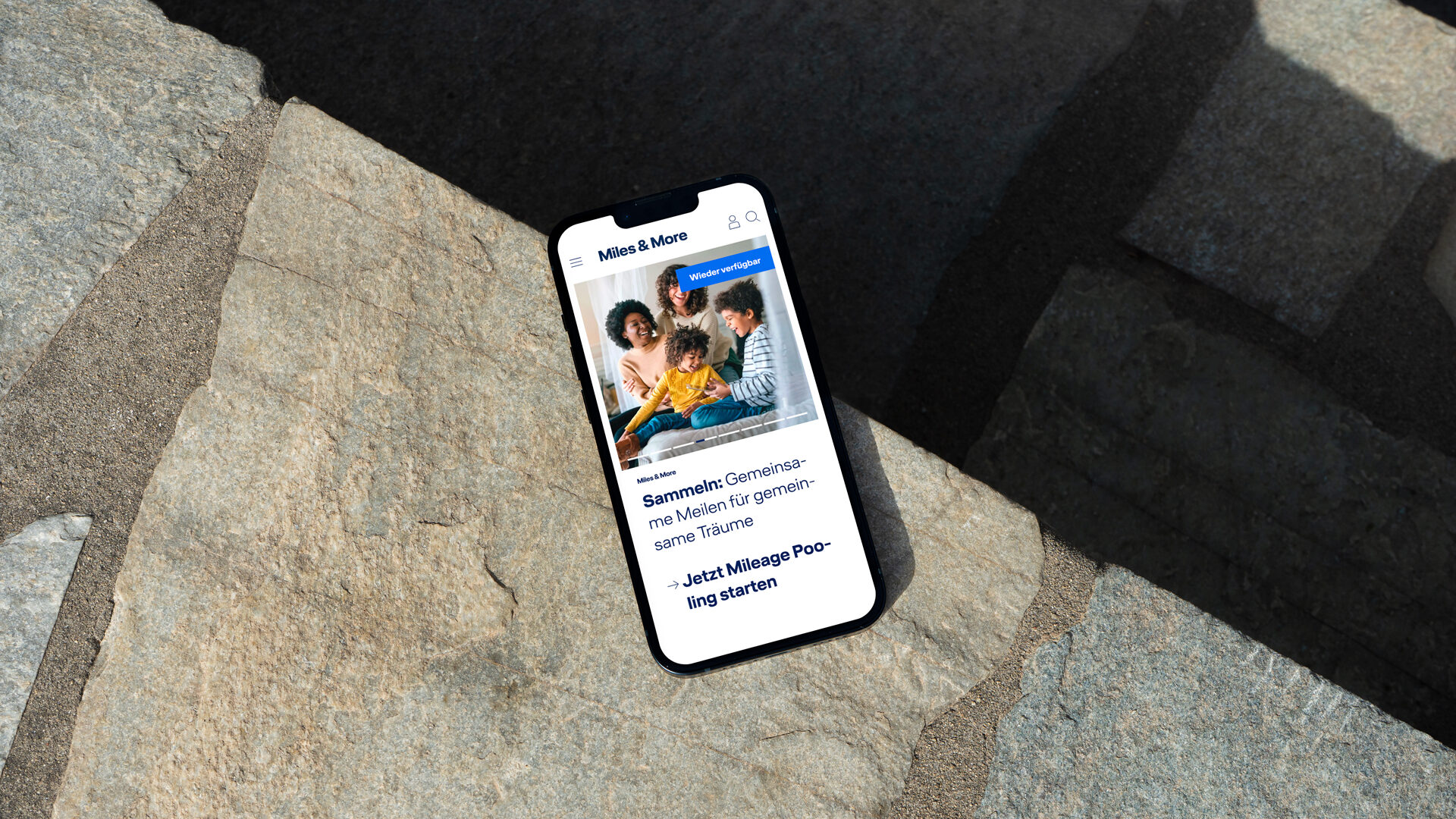 A mobile phone shows the Miles and More Homepage