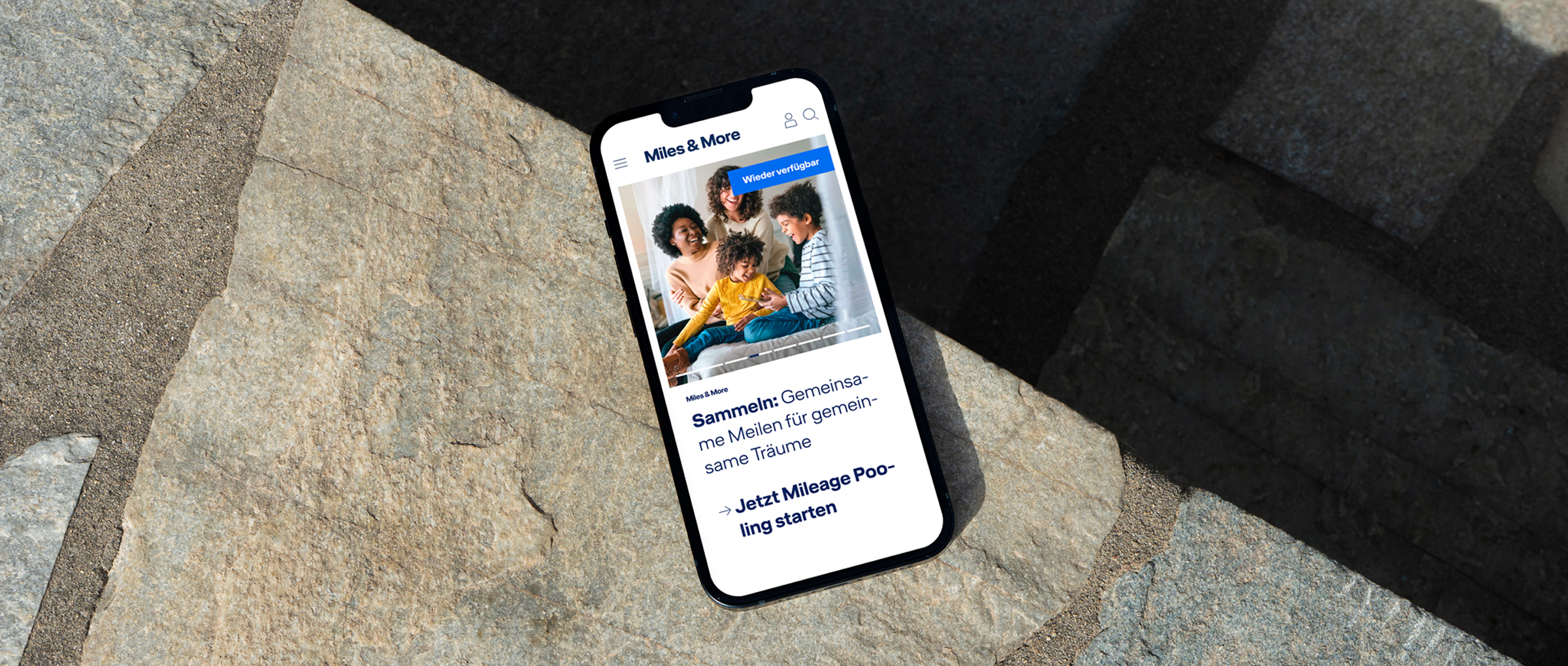 A mobile phone shows the Miles and More Homepage