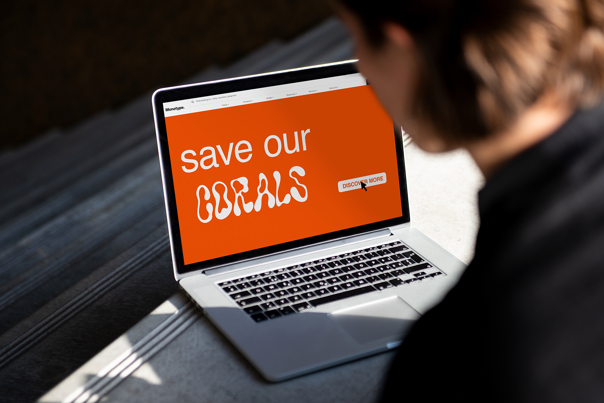A person is looking at a laptop showing the Recoral Website